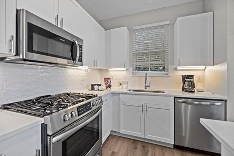 a kitchen with stainless steel appliances and white cabinets